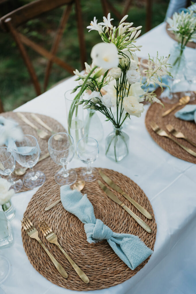 Assiette, serviette bleue et fleurs sur une table de mariage