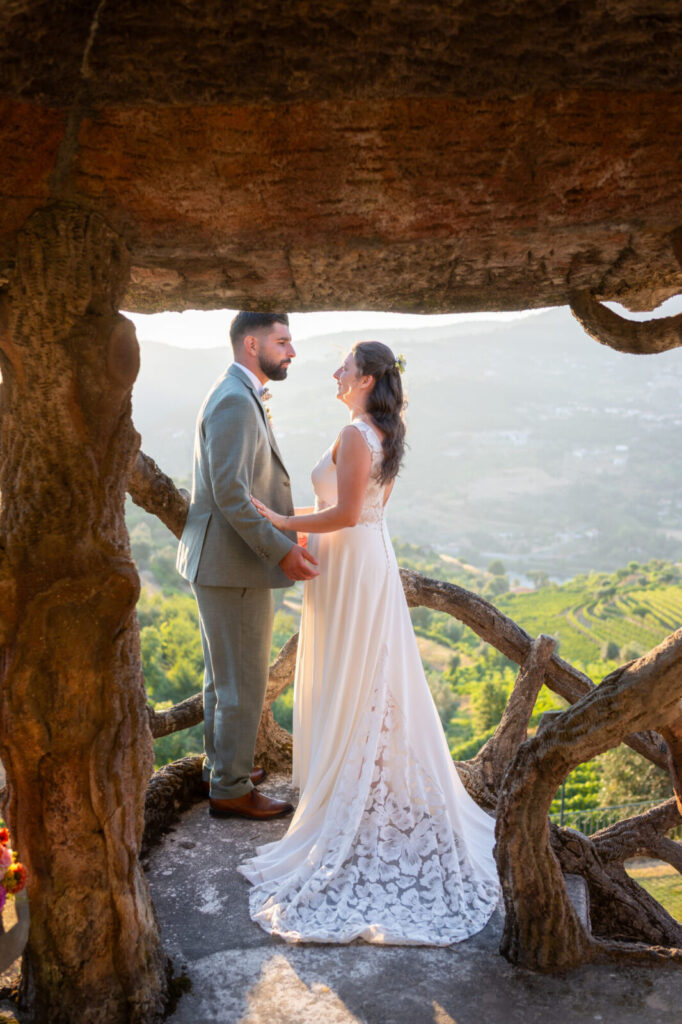 Couple de mariés debout sous un arbre, face au paysage