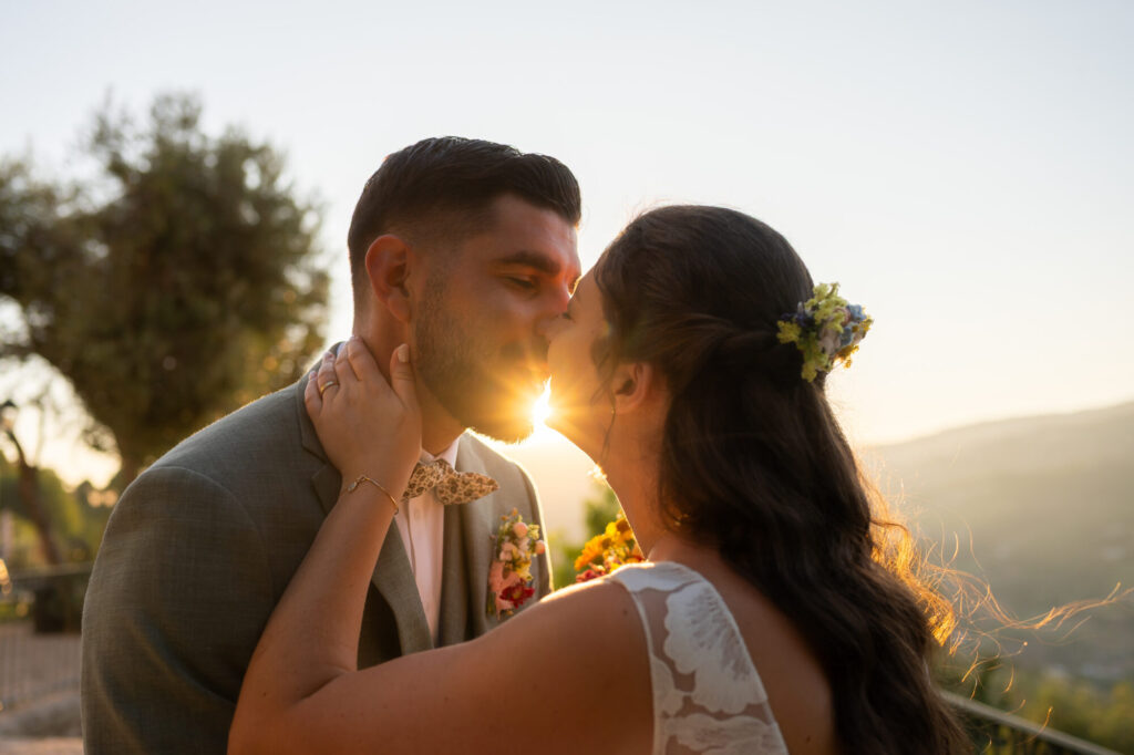 Couple de mariés s’embrassant au coucher du soleil