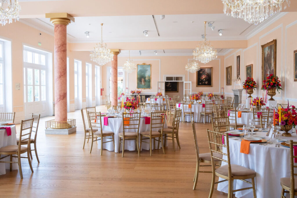Salle de réception dressée avec tables fleuries et chaises dorées