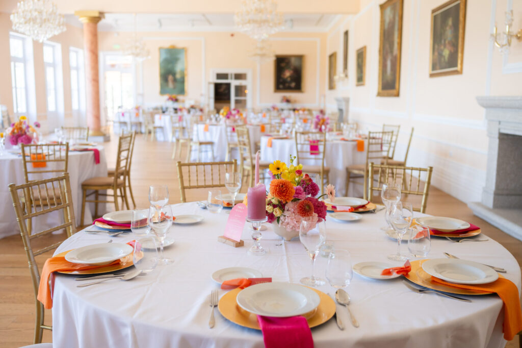 Tables de réception dressées avec fleurs colorées et serviettes roses