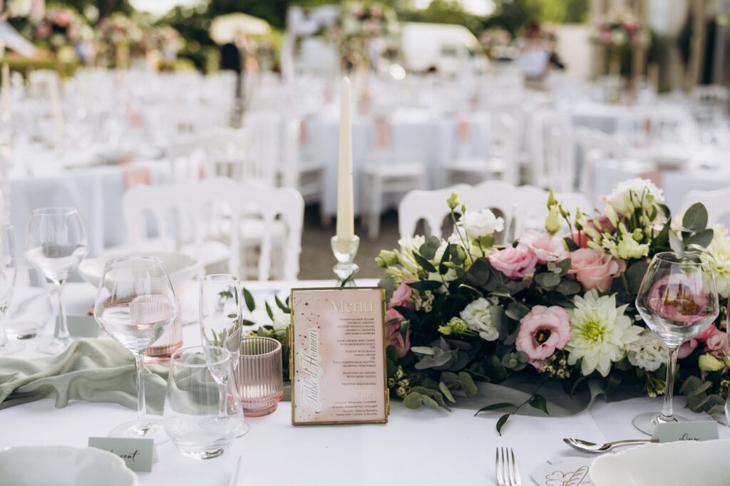 Table de réception blanche avec composition florale rose et blanche