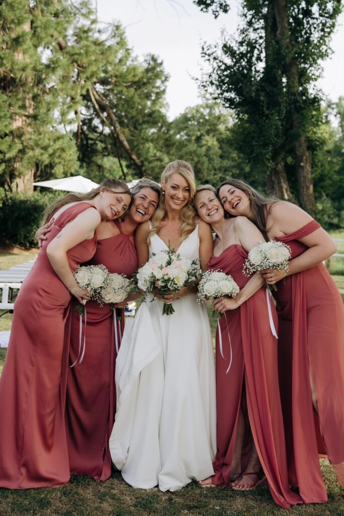 Mariée entourée de quatre demoiselles d’honneur tenant des bouquets