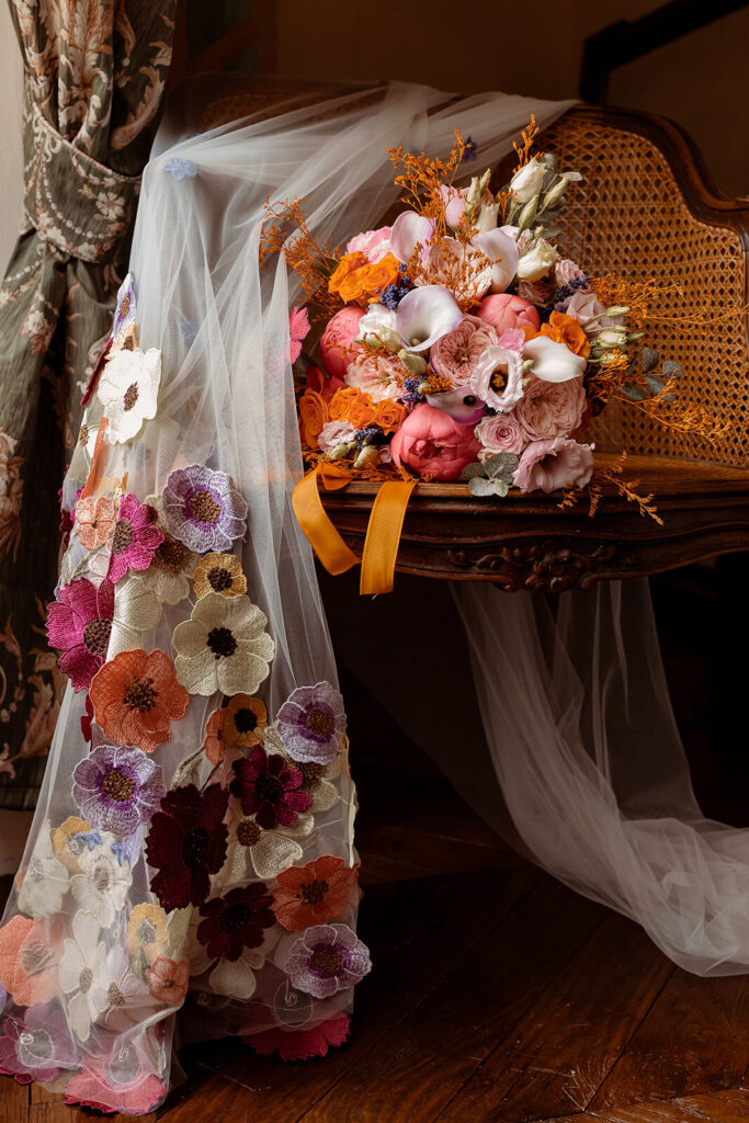 Bouquet coloré posé sur une chaise, voile orné de fleurs
