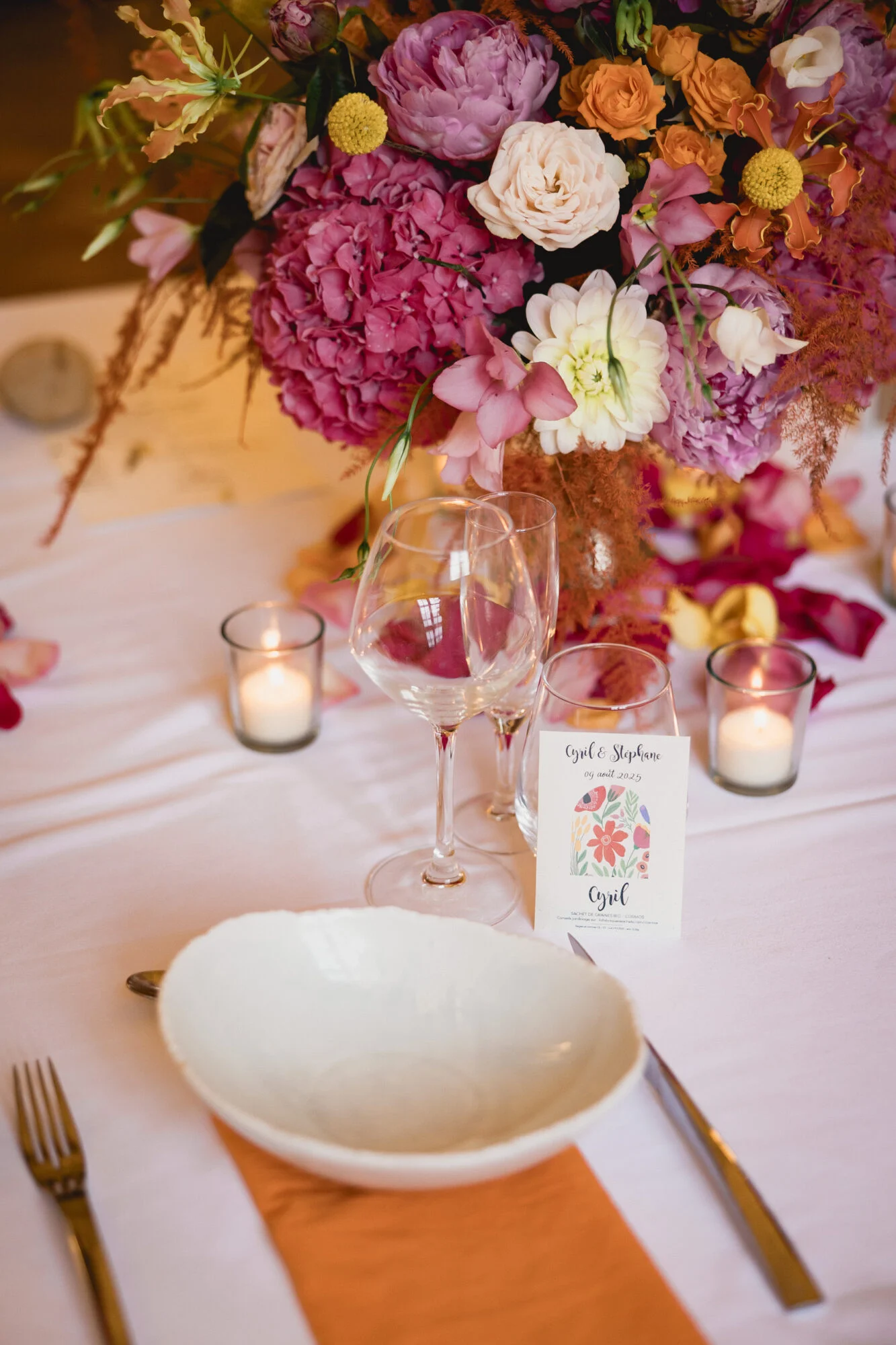Organisatrice de mariages : table décorée de fleurs Table dressée avec grand bouquet fleuri, bougies et vaisselle